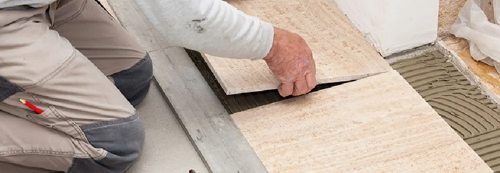 Person verlegt Fliesen